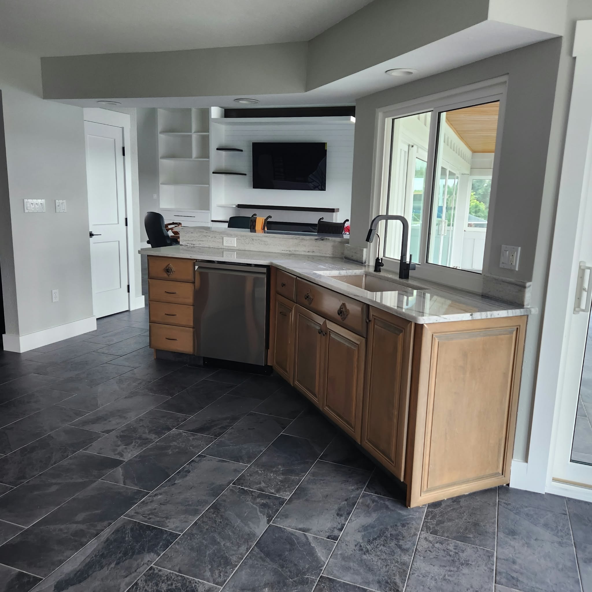Renovated kitchen with wood cabinets, granite countertops and slate tile flooring