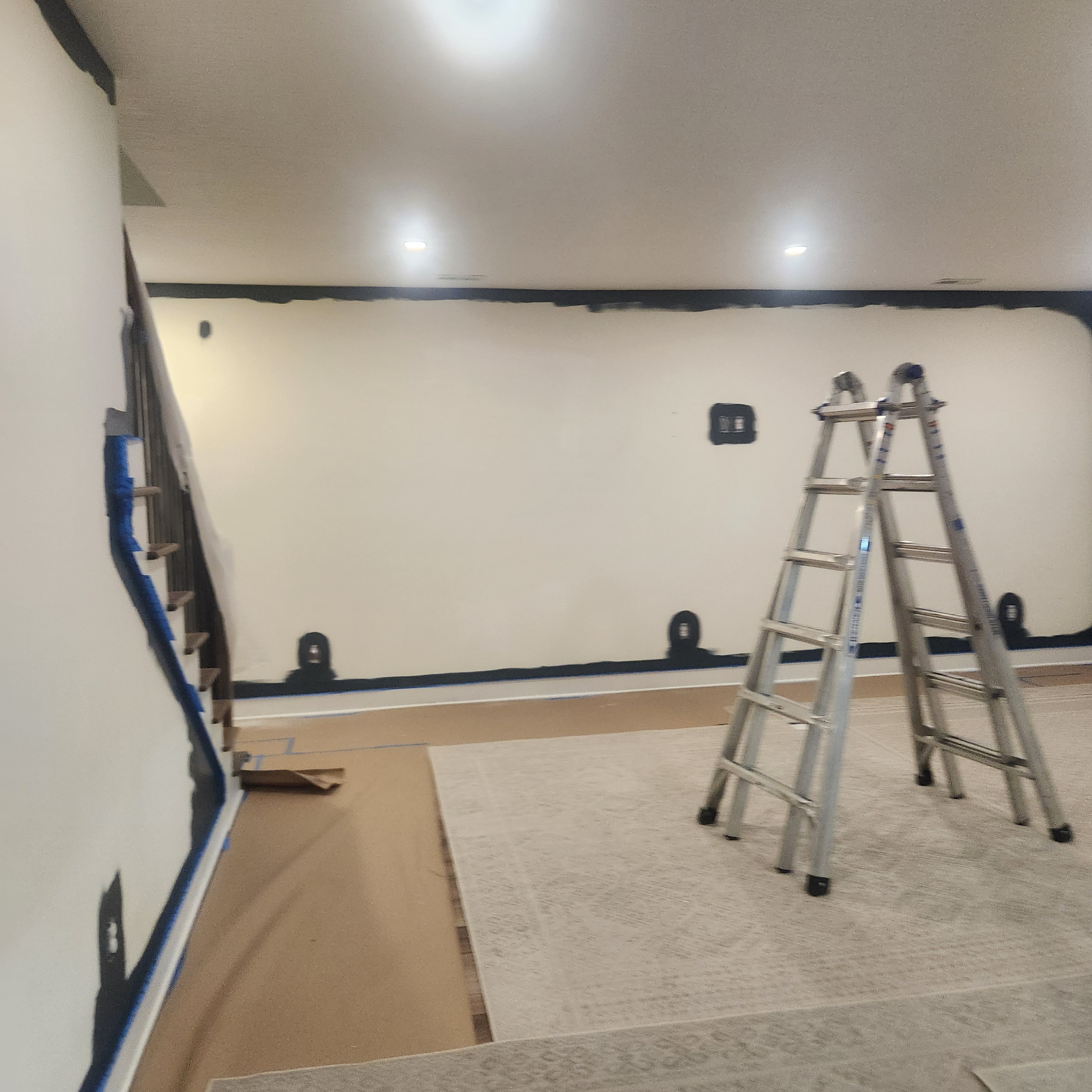 Room interior during painting prep with ladder and taped trim
