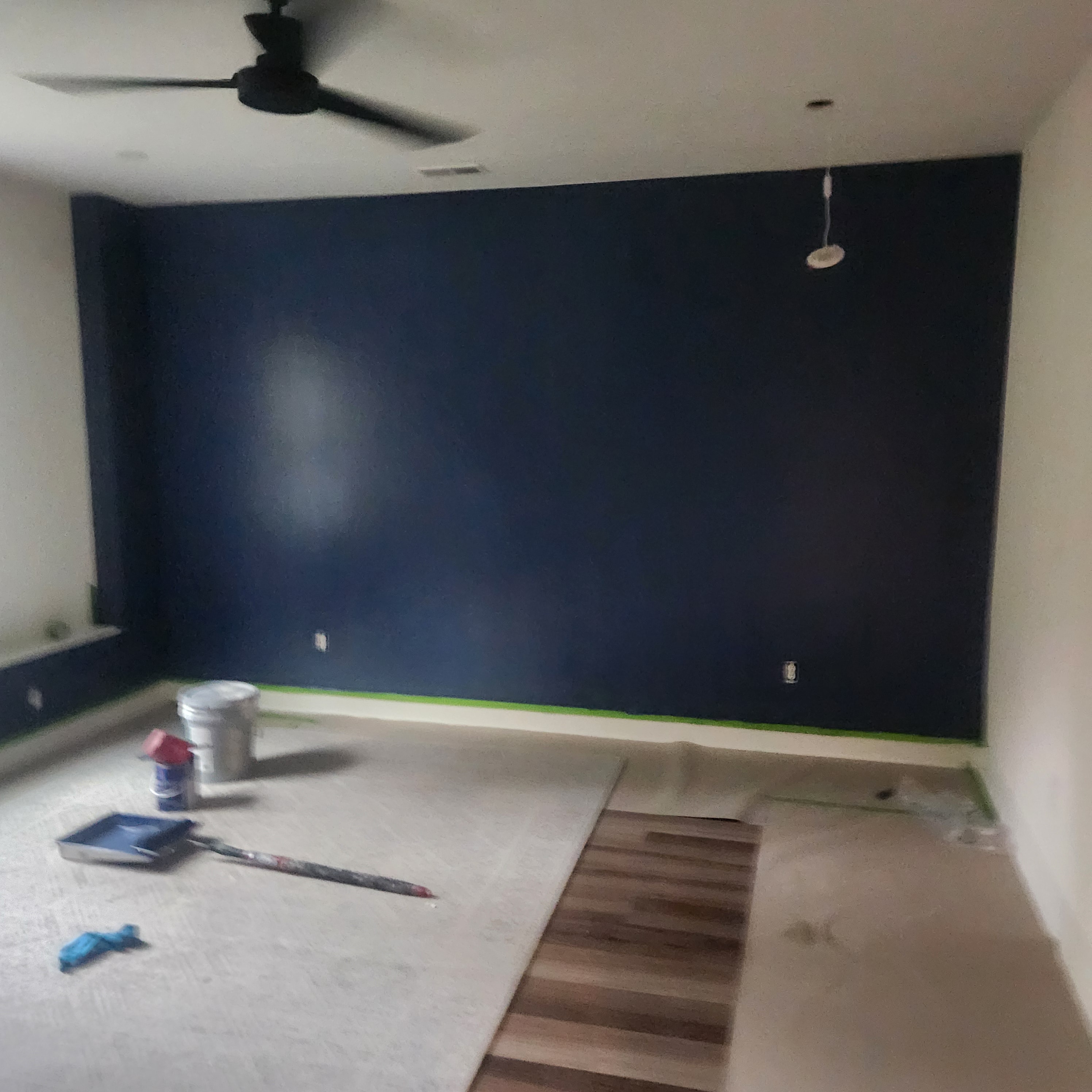 Freshly painted navy blue accent wall in a room under renovation